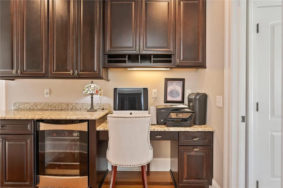 Conveniently located between the kitchen and dining room, this built-in workstation features rich cabinetry, granite counters, and a built-in wine chiller — the perfect blend of function and sophistication.