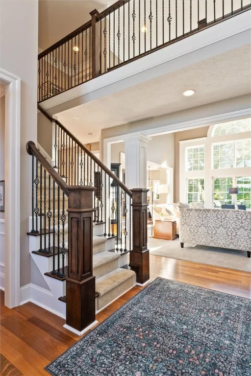The great room impresses with soaring ceilings, a dramatic wall of windows, and a catwalk overlook that enhances the open feel. A gas fireplace anchors the space, creating a cozy yet grand gathering area filled with natural light and beautiful views.
