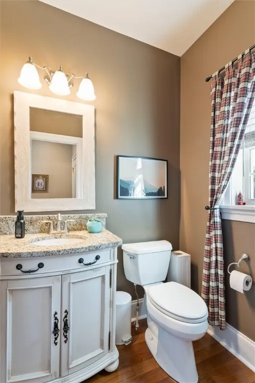 Stylish first-floor powder room featuring a custom vanity with granite countertop, warm tones, and thoughtful design—perfect for guests.