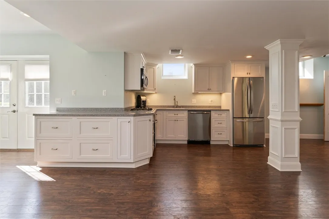 This beautifully finished lower-level apartment offers incredible flexibility — perfect as a recreation space, in-law suite, or private teen retreat. Thoughtfully designed with the same high-end finishes as the main home, it features a full kitchen with stainless steel appliances, gas cooktop, and ample cabinetry. The open layout allows for both living and dining areas, while natural light and walkout access make this space feel bright and inviting.
