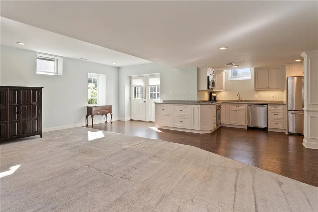 This beautifully finished lower-level apartment offers incredible flexibility — perfect as a recreation space, in-law suite, or private teen retreat. Thoughtfully designed with the same high-end finishes as the main home, it features a full kitchen with stainless steel appliances, gas cooktop, and ample cabinetry. The open layout allows for both living and dining areas, while natural light and walkout access make this space feel bright and inviting.