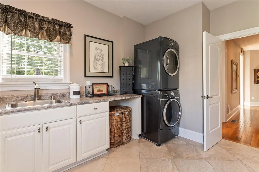 Imagine doing laundry in this bright, cheerful space — where natural light, generous counter space, and convenient storage make everyday chores feel effortless. Functional meets inviting, right off the main hall for easy access and flow.