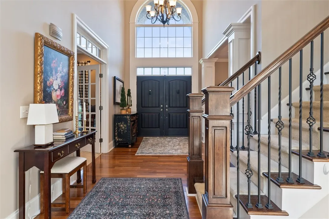 The moment you step inside, you’re greeted by soaring ceilings, elegant millwork, and a stunning view straight through to the sun-filled great room—setting the tone for the sophistication found throughout this home.