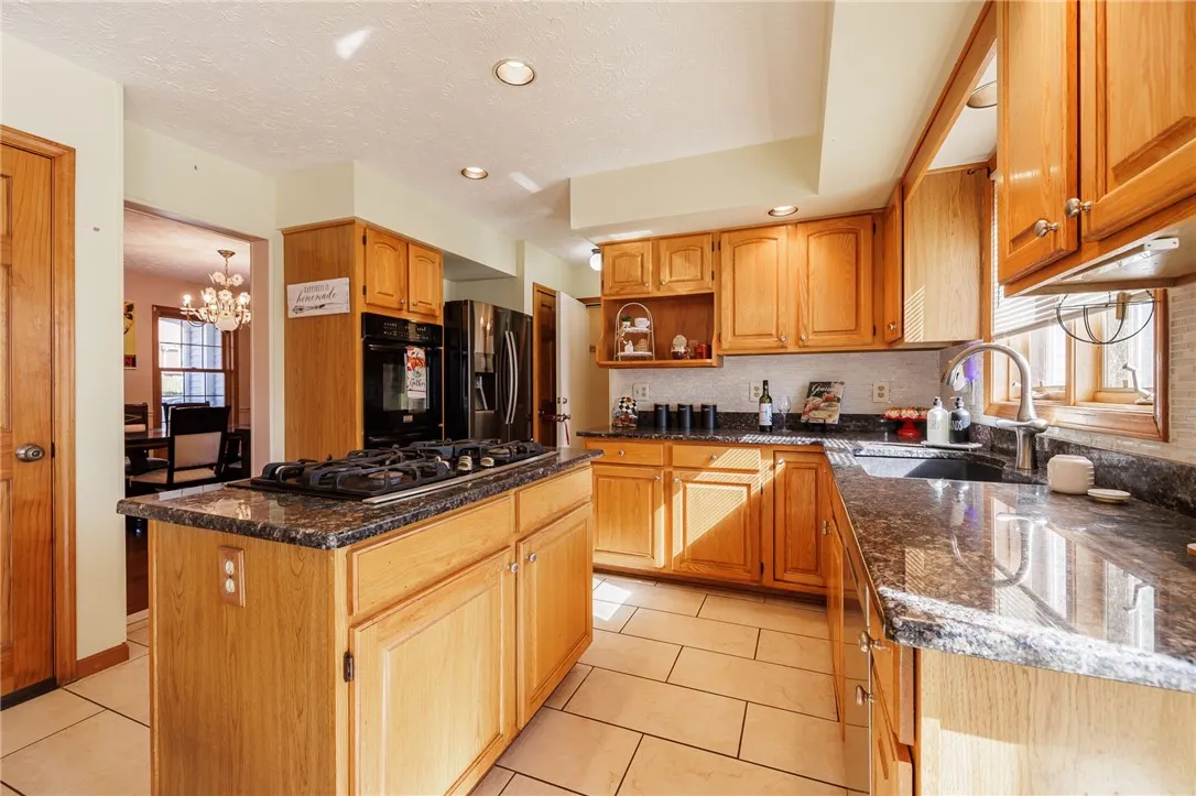 Granite counters, center island, and stainless appliances in kitchen
