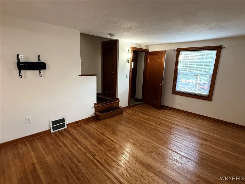 Front foyer and staircase view from the kitchen. Notice the coat closet on the landing.