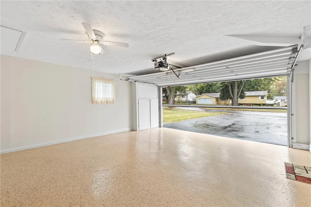 2 Car Garage showcasing the Epoxy Floor and Motorized Drop Screen!