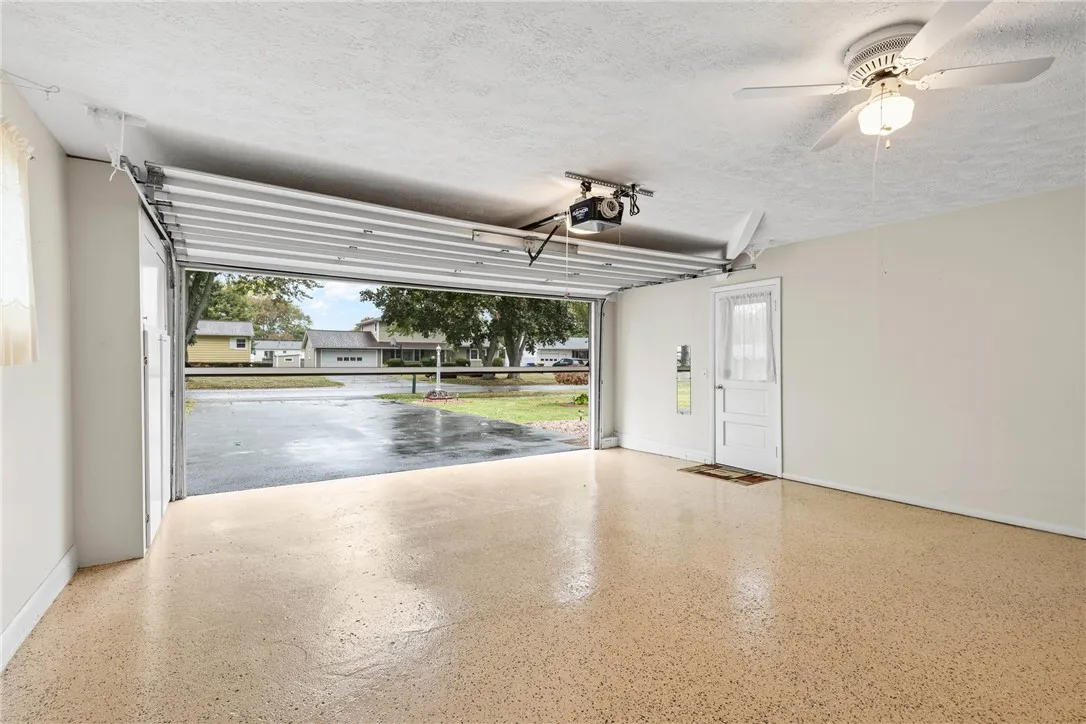 2 Car Garage showcasing the Epoxy Floor and Motorized Drop Screen!