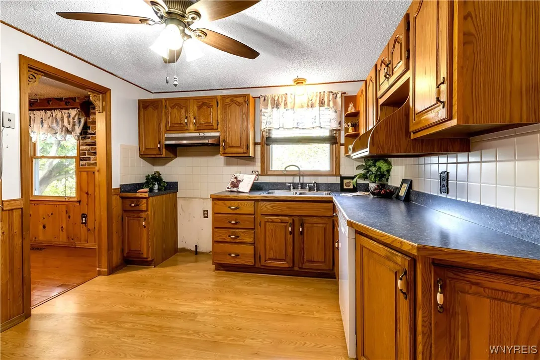 Lots of oak style cabinets, ceramic tiled backsplash, laminate floor+ built-in dishwasher