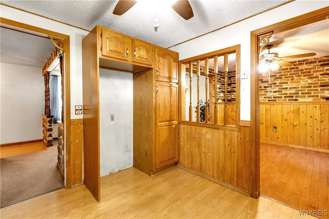 Kitchen has alcove for refrigerator, pantry with pull out drawers, half spindled wall + wood framed entry