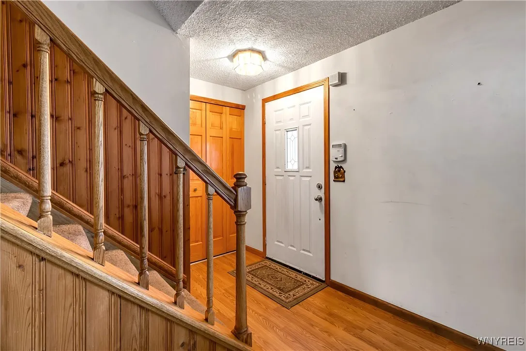 Front door entry with guest closet + laminate floor