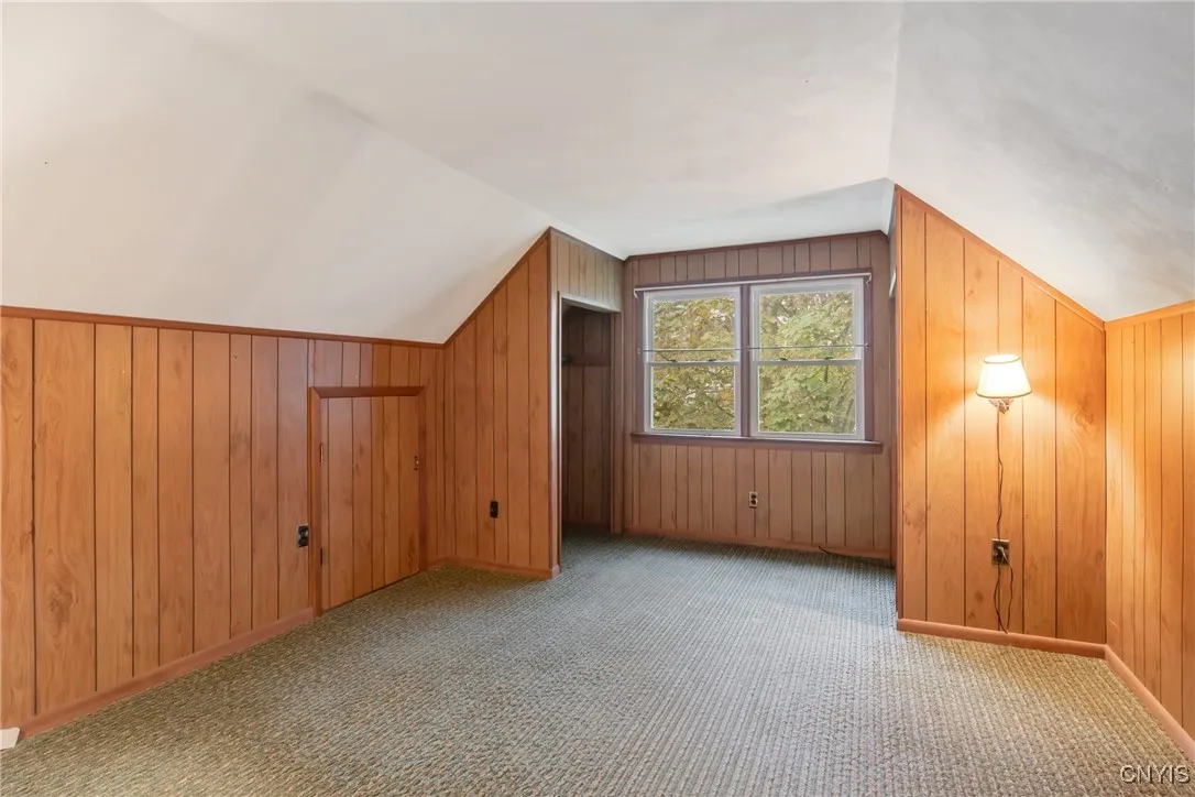 Bedroom #5 with wood paneled walls, 2 closet areas and cubby storage area on each side wall.