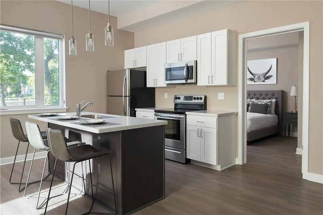 Typical 1-bedroom kitchen with breakfast bar/kitchen island, stainless steel appliances, dishwasher, etc.