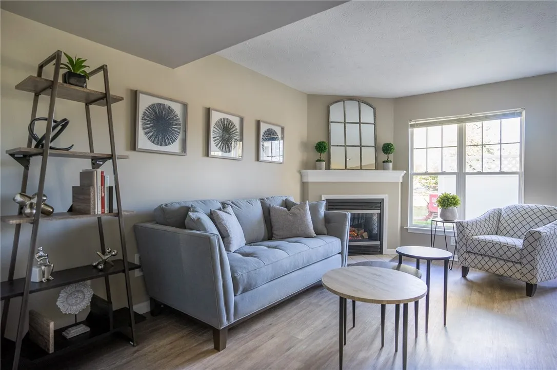 Typical living area of great room with gas fireplace and faux wood flooring
