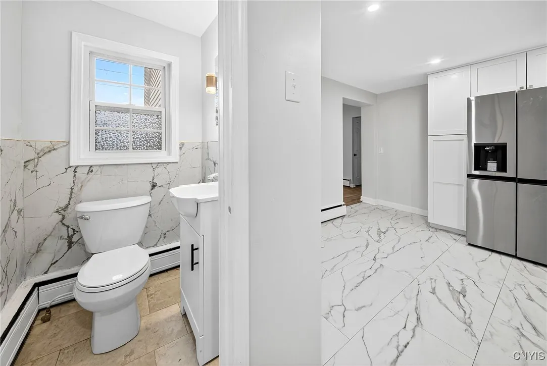 A convenient half bath is located just off the kitchen for added functionality.