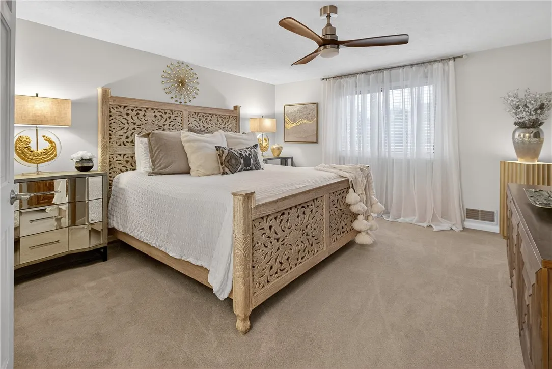 BEDROOM IS LARGE ENOUGHT FOR A KINGSIZE BED AND A CHEST OF DRAWERS ON EITHER SIDE. WINDOW HAS WOODEN BLINDS. LIGHTED CEILING FAN