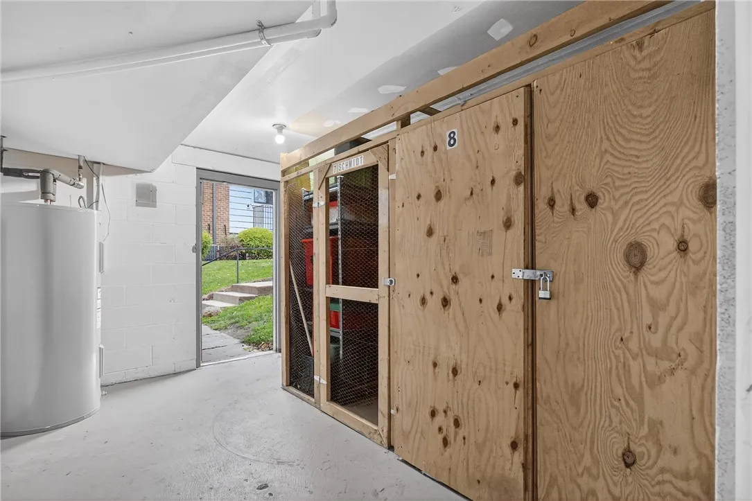 STORAGE UNIT #8 IN DRY BASEMENT. EXTERIOR DOOR PROPPED OPEN TO SHOW HOW CONVENIENT TO BRING YOUR BELONGINGS IN FROM THE PARKING LOT JUST THOSE FEW STEPS AWAY