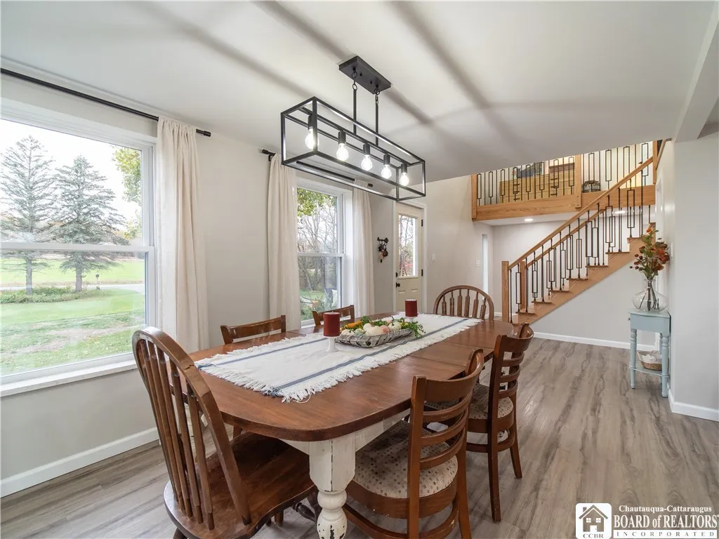 The front entry leads to the dining area and is flanked by a wall of windows. There is plenty of room to expand the dining table to accommodate the largest of groups.