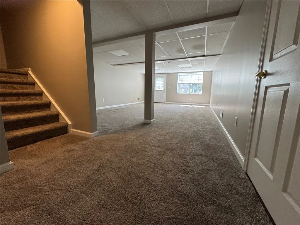 View of typical partially finished walk-out basement with doorway to private patio