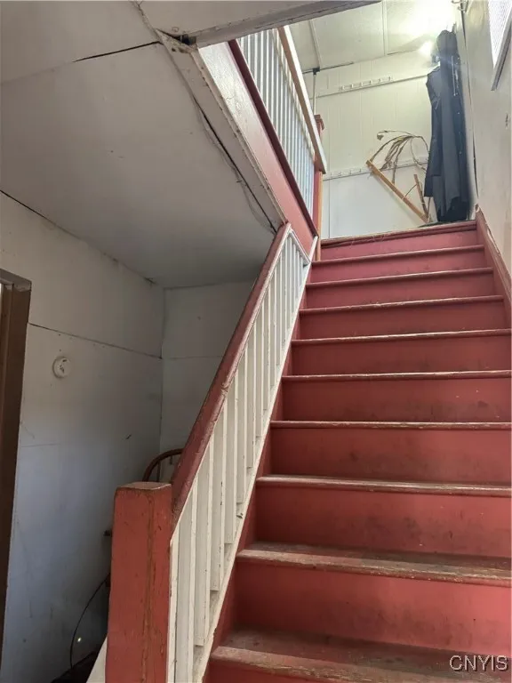 hallway with lower floor apartment entry, stairway to upper floor landing