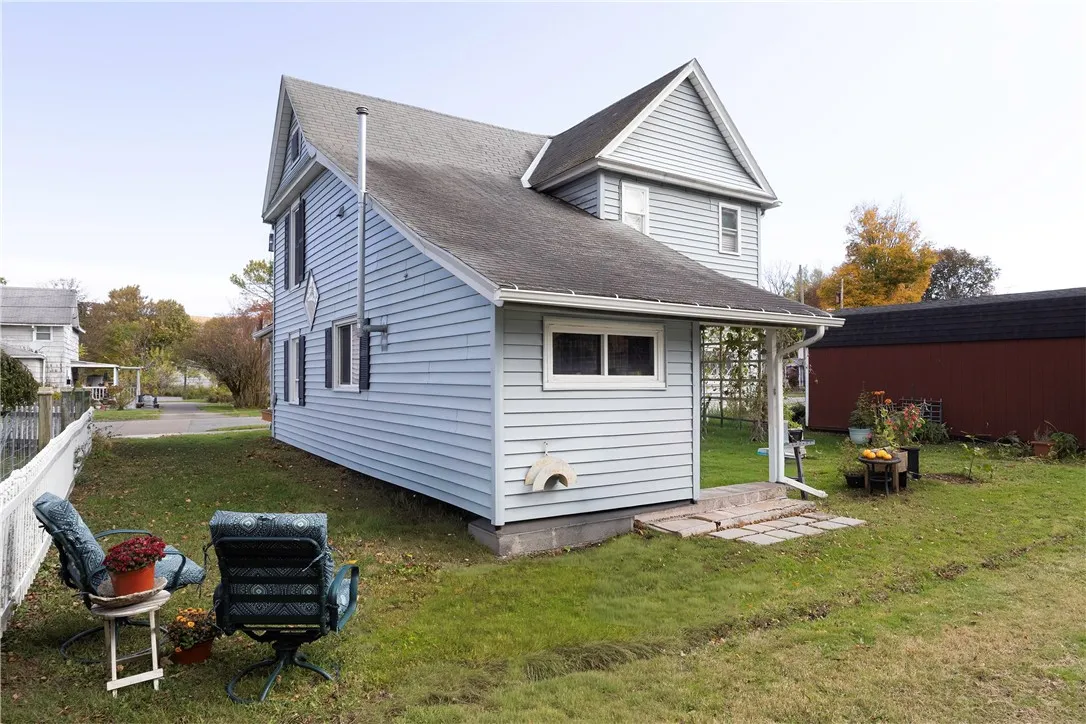 Back Exterior – 121 Owego Street, Rear view of the home showing the side entry, level backyard, and garden area. Perfect spot to relax outdoors with room for seating, plants, and seasonal entertaining.