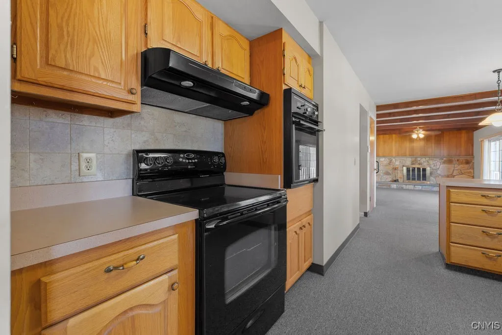 This kitchen has been well maintained with wood cubpoards and black appliances.