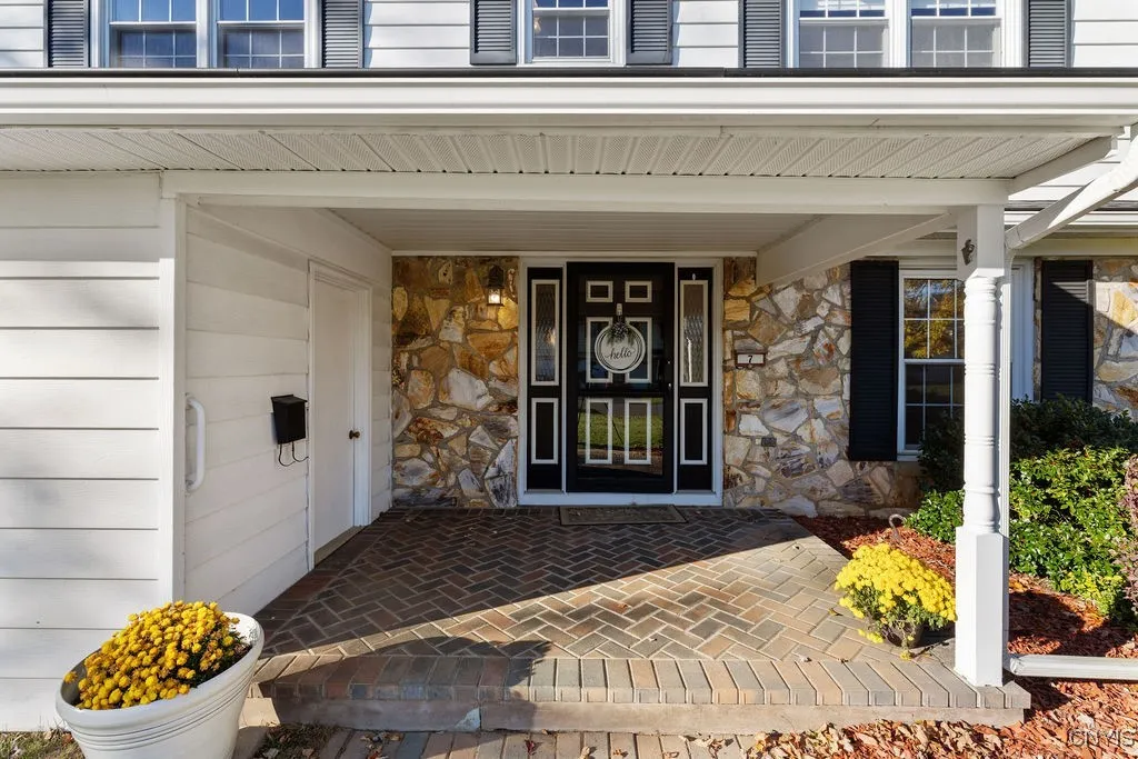 Truly welcoming brick paver front porch that has been recently remodeled by McClurg.