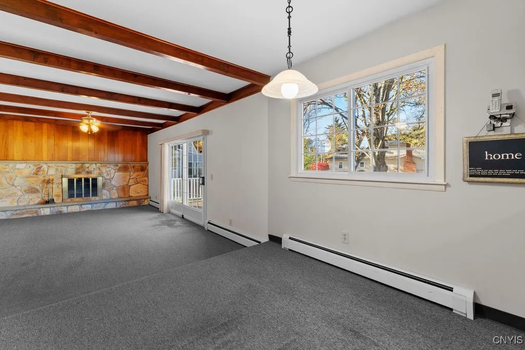 Eat in area with step down family room with wood burning fireplace, beams and slider to deck.
