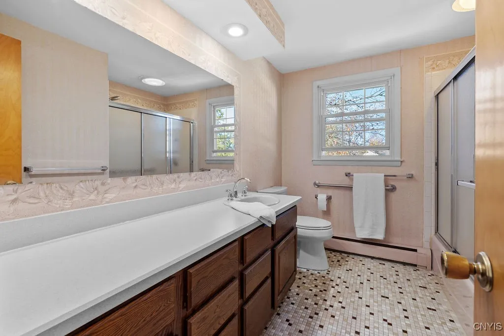 Second floor full bath with tub, tile flooring, large vanity and recessed lighting.