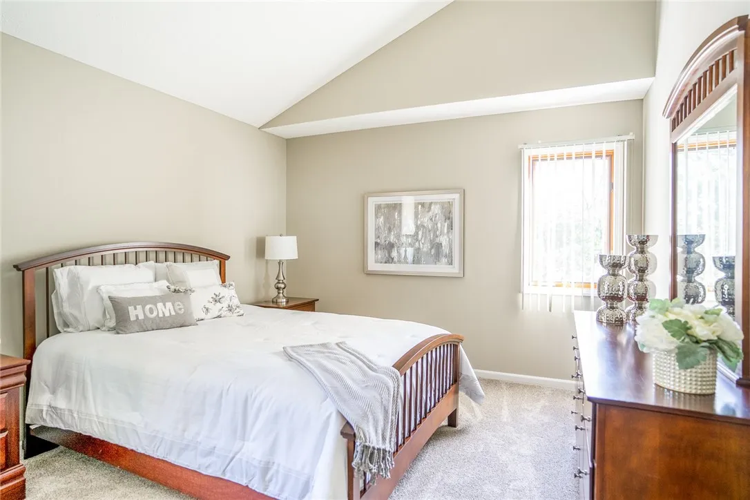 Typical bedroom with cathedral ceilings and wall-to-wall carpeting