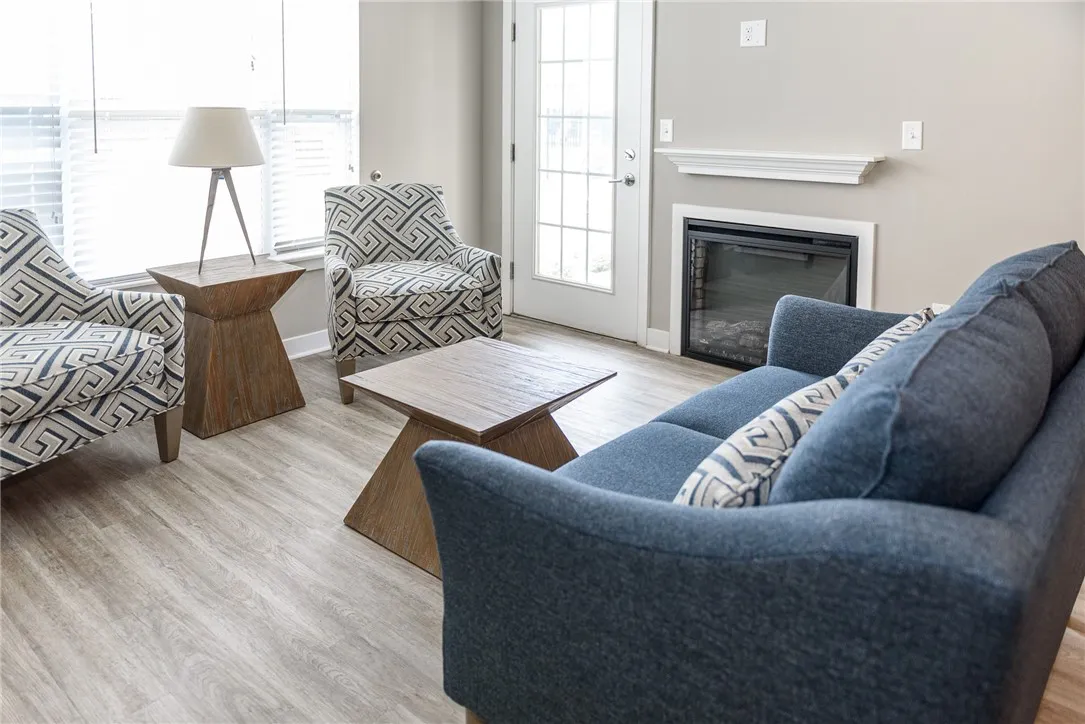 Typical great room with focus on the living area & fireplace as well as access to the balcony/patio