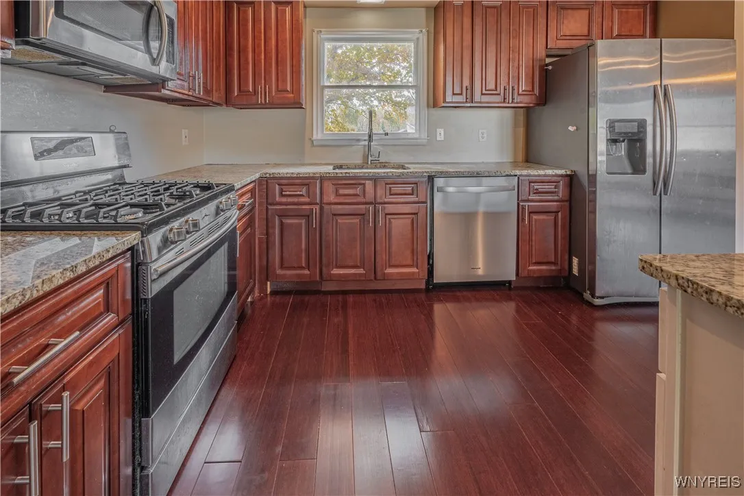 Beautifully updated kitchen with granite counters, an island, stainless steel appliances, and a pantry.