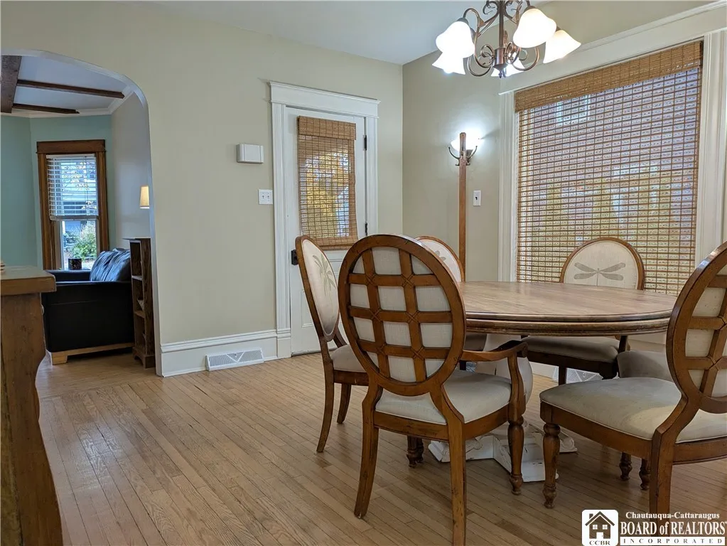 Dining room with oak flooring is located between the kitchen and living room