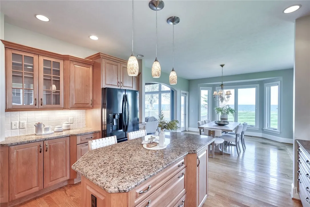 The kitchen blends beauty and practicality with quality cabinetry, granite counters, tile backsplash, and a center island — plus a spacious walk-in pantry that keeps it all effortlessly organized.