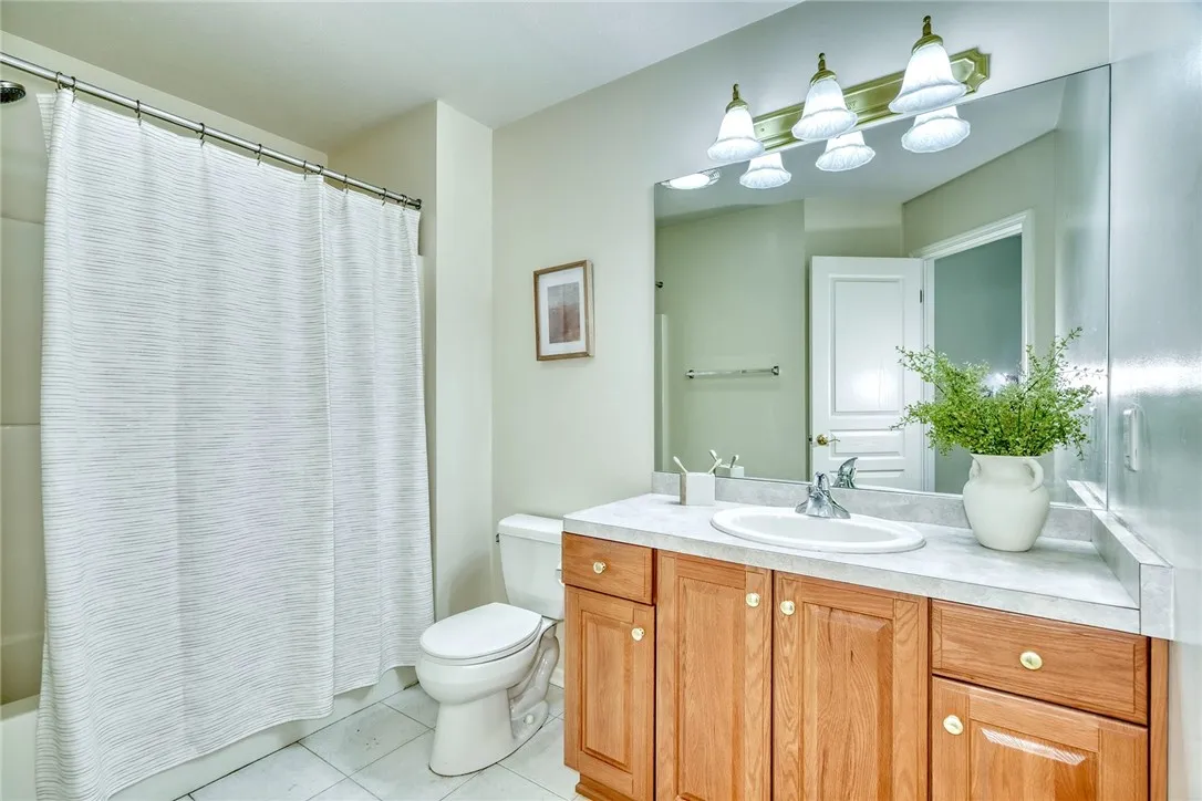 2nd floor main bath with tiled flooring, tub/shower combo and generous vanity space.