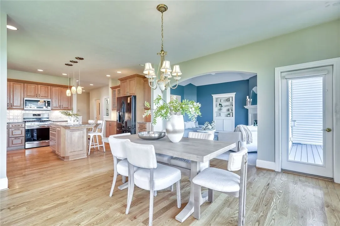 The kitchen blends beauty and practicality with quality cabinetry, granite counters, tile backsplash, and a center island — plus a spacious walk-in pantry that keeps it all effortlessly organized.