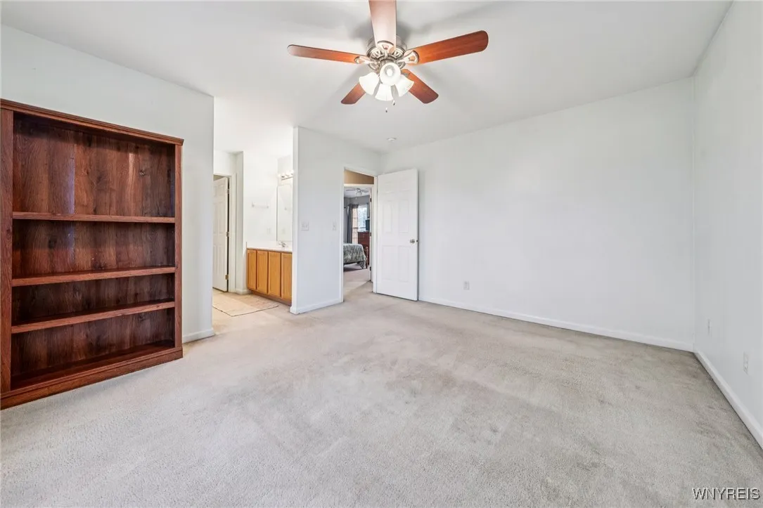 primary bedroom with bathroom/closet hallway entrance. Able to see fourth bedroom through the far door across hall way