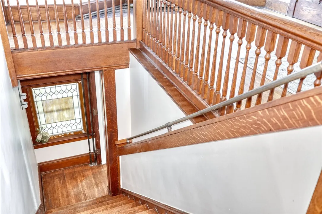 The sweeping wood banister and sunlit landing create a moment of pause — the kind of classic staircase that makes the home feel both stately and welcoming