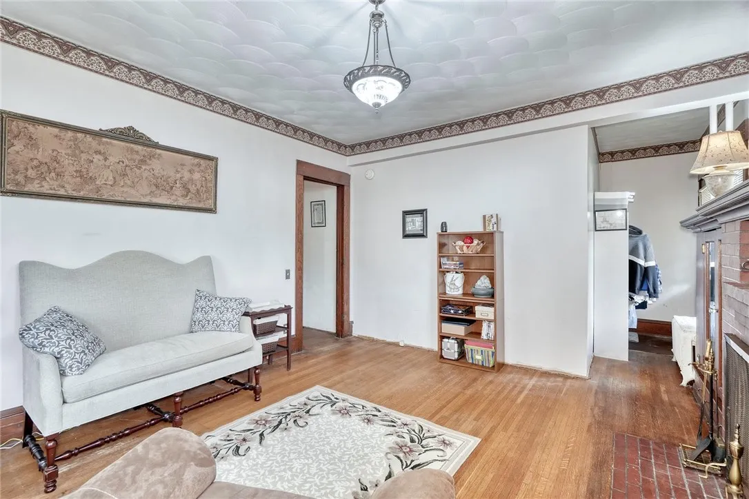 Through French doors, a library-style living room adds built-in bookcases, a second brick fireplace, and its own private side entry