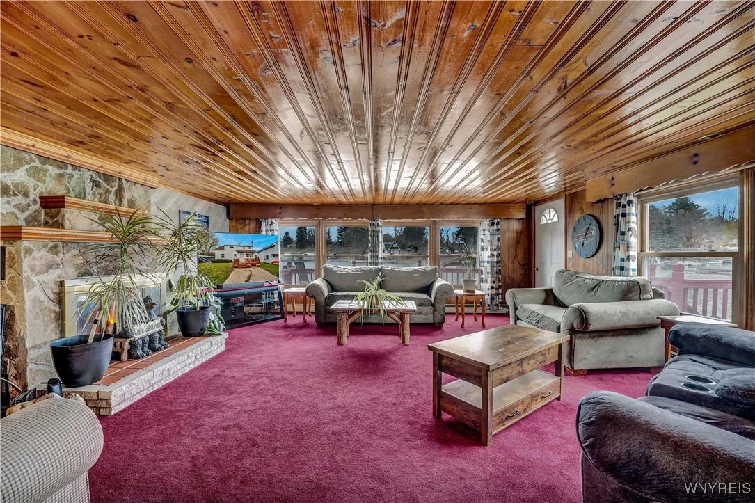 Living room with views of lake on two sides, stone fireplace