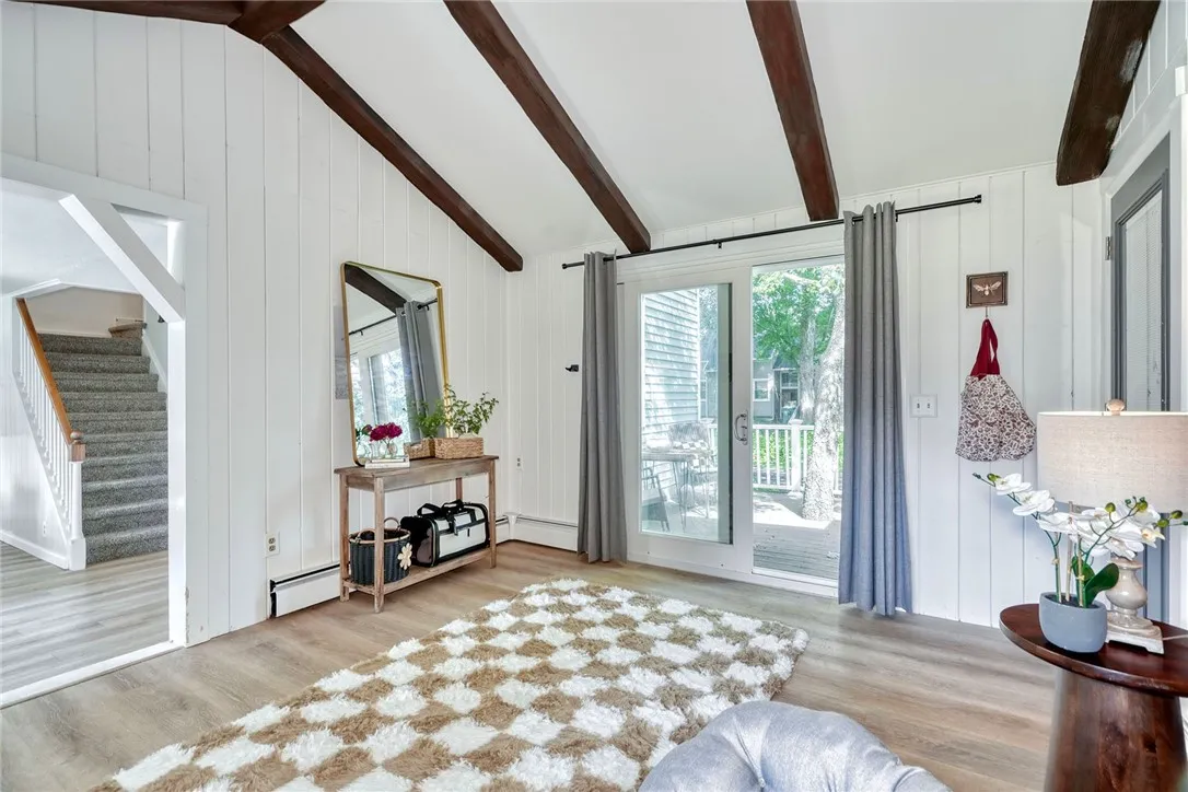 Vaulted bonus room with beams, brick wall, and slider to deck - Flexible uses!! Perfect for office, mudroom, or sitting room.