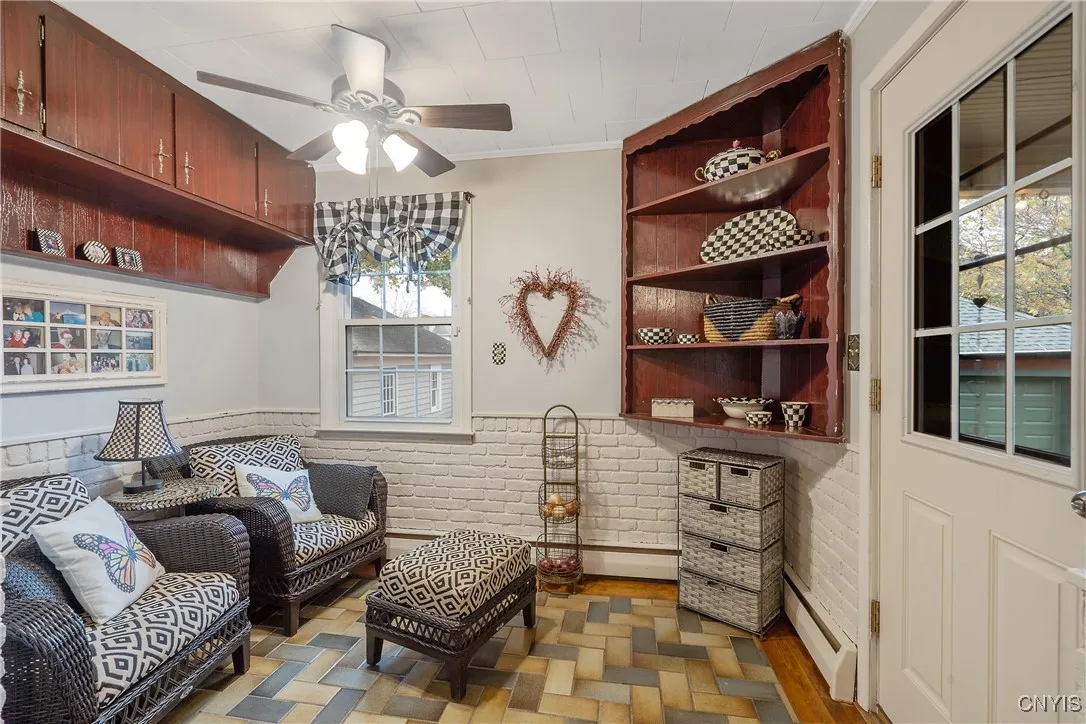 Here is a closer look at the eat-in area, currently being used as a sweet reading nook. High-set cabinets and a corner shelving unit make this a very useful room.