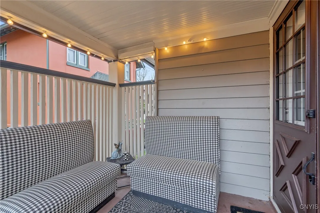 Now we come back through the kitchen, and out the pedestrian door at the breakfast nook which bring us to this quaint back porch. The slatted privacy wall allows airflow while you relax outside.