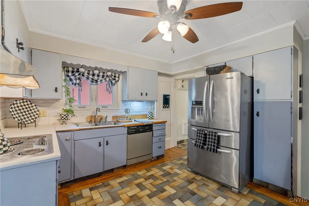 Now we turn the corner and enter the kitchen. The perpendicular tile pattern is enveloped in a hardwood track at the exterior. The current owner retained the art deco cooktop and oven as part of the multi-era decor.