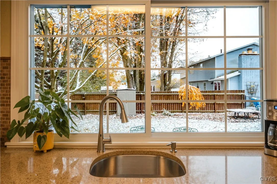 A view from the prep sink into the fenced rear yard. And, of the granite counters.