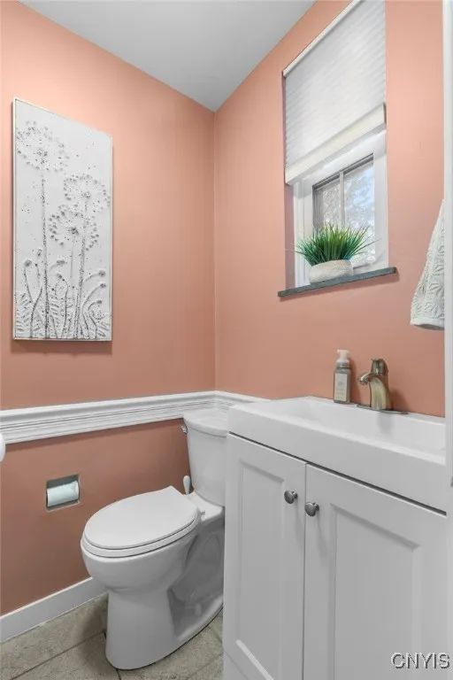Half bath with tile flooring, freshly painted and nice storage on other side of wall.