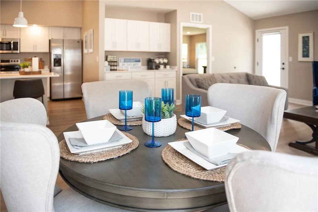 Typical Dining Area in Great Room with Coffee Bar in Background & Doorway to Primary Bedroom