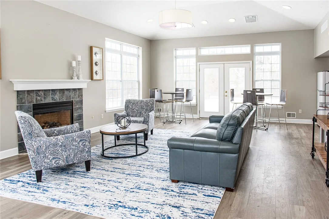 Resident Clubhouse (AKA Community Room) with fireplace, kitchenette, and high-top tables near French doors to outdoor patio