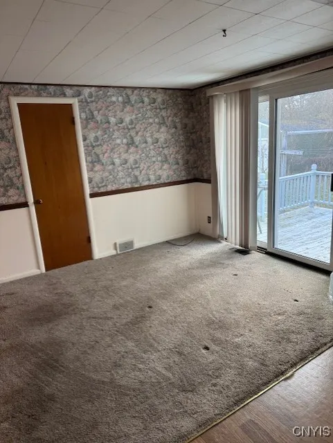 SLIDER LEADS TO LARGE DECK AND PARTIALLY FENCED BACKYARD