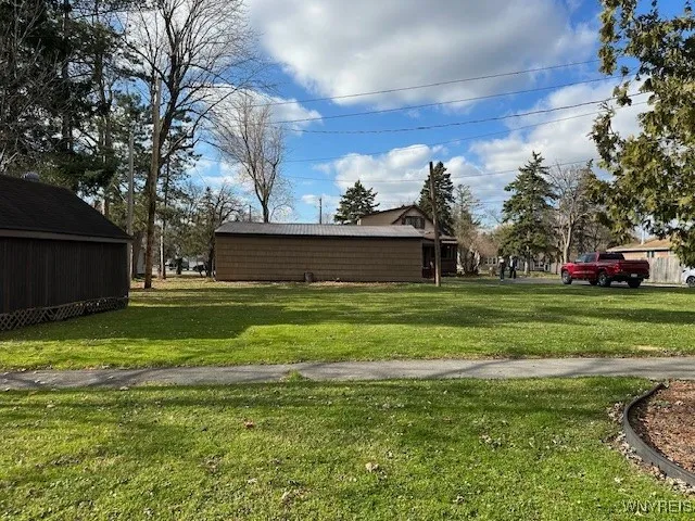 view of four car garage from rear lot with storage shed on left