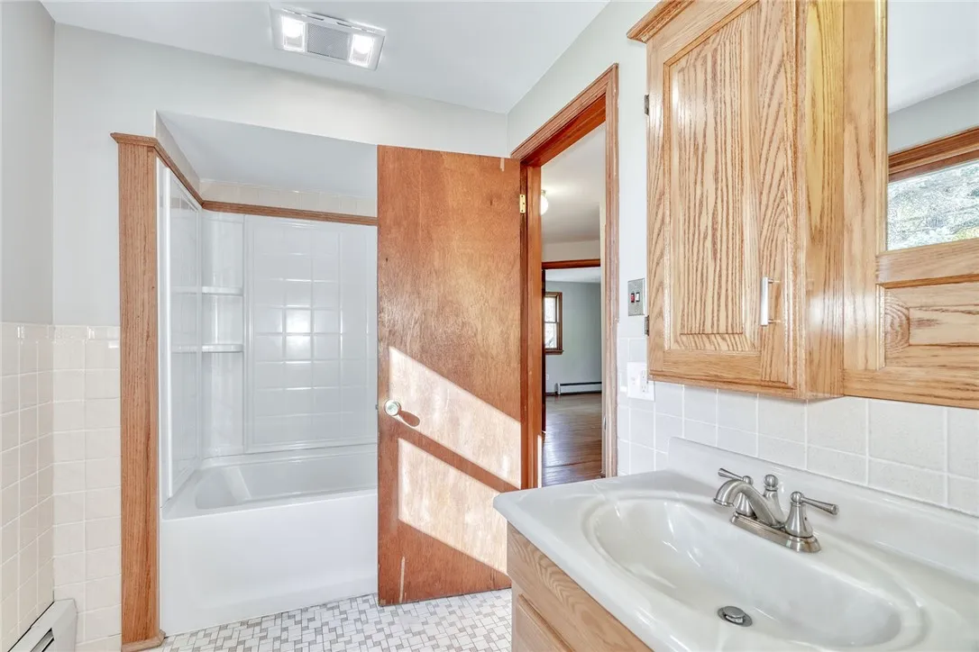 2nd floor MAIN bath is tiled and has a large double sink vanity and a newer tub/shower surround!